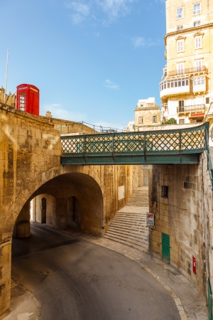 Traditional narrow street, old houses, arch, tunnel and footbridge in Malta. Maltese architecture in Valletta, Maltaの写真素材