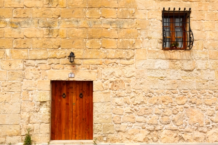 old wooden front door and window to the house in the Mediterraneanの写真素材