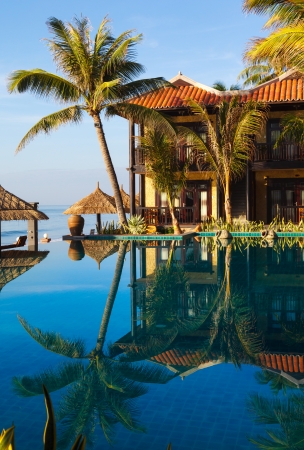 pool, palm tree on the background of the sea and sky at dawnの写真素材