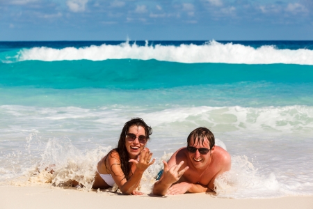 Young romantic couple laying on sandy beautiful tropical beach Seychelles La Digueの写真素材