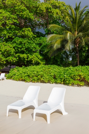 sunbeds on the beach in Seychelles on a background cloudy skyの写真素材