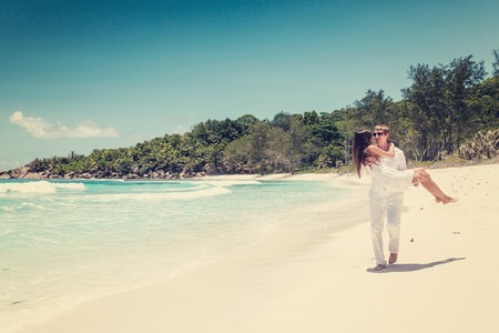 Young couple married on sandy beautiful tropical beach Seychelles La Digueの写真素材