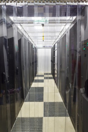 racks in the data center in the cold aisle through the transparent curtainsの写真素材