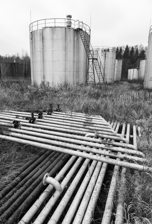 Old rusty pipes and tanks at an abandoned oil refineryの写真素材