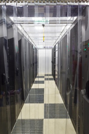 racks in the data center in the cold aisle through the transparent curtainsの写真素材