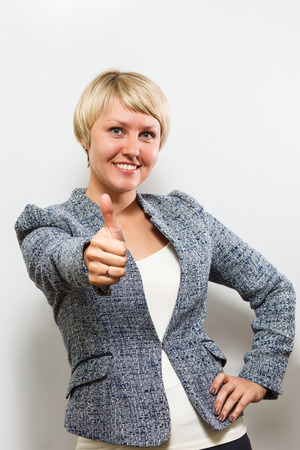 Thumb up. Smiling business woman with blond short hair on white background. open smileの写真素材