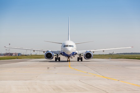 White jet airplane on the runway on a sunny day on blue sky backgroundの写真素材