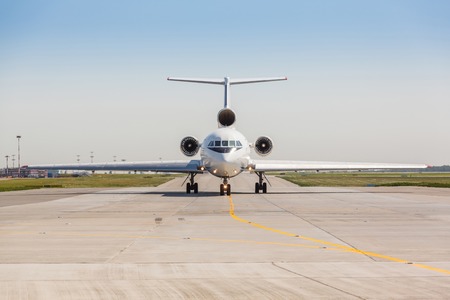 Russian white jet airplane on the runway on a sunny day on blue sky backgroundの写真素材