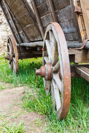Old wooden cartwheel with rusty steel rim and green grass closeupの写真素材