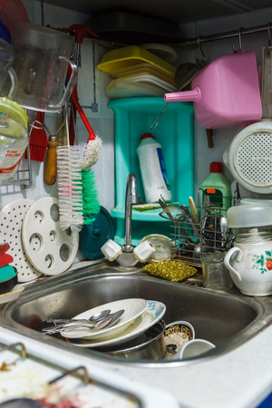 Pile of dirty dishes in sink and counter top, mess in the kitchenの写真素材