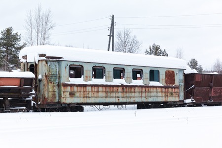 Abandoned  rusty  wagons on narrow-gauge railway under the snowの写真素材