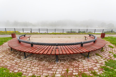 beautiful foggy morning in the russia, wooden bench and pondの写真素材