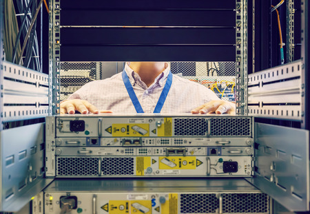 IT Engineer installs equipment in the rack in datacenterの写真素材
