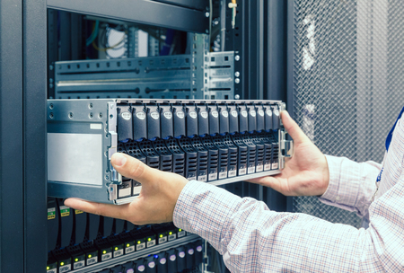 IT Engineer installs equipment in the rack in datacenterの写真素材