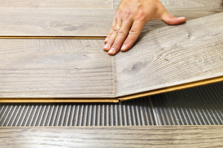 Laying laminate flooring in a flat the hands of master closeupの写真素材
