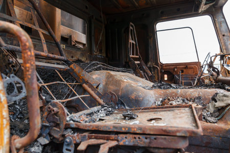 truck completely burned on the roadside, rusty cabin and car parts closeup