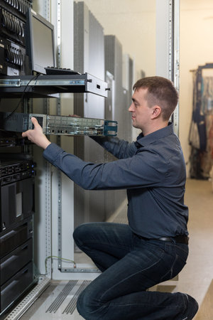 IT Engineer installs equipment to rack in datacenter