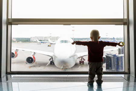 Infant waiting for his flight at the airportの写真素材