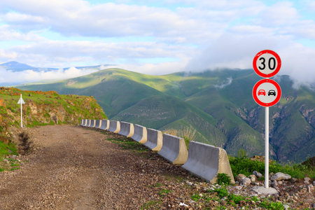 dirt road along the edge of the cliff and road signs on the highland valley from the height of the...