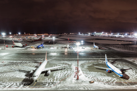 MOSCOW, RUSSIA - 25 december 2017: Night panoramic view of Terminal A of Vnukovo International Airport and airport building with teletraps and apron with airplanesのeditorial素材