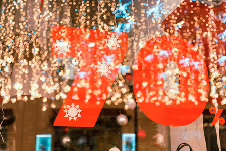 Large Sale 70 percent discount, a banner on the glass with the reflection of New Years garlands.の写真素材
