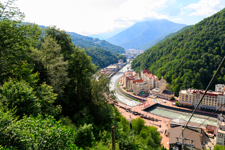 Mountains and Aibga Ridge with cable car and low clouds. Remnants of snow and new green grass on Mountains near the ski resort in Krasnaya Polyana. Sochi, Russia.の写真素材
