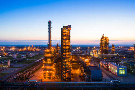 Oil refinery plant industry, Refinery factory. oil storage tank, rectification column and pipeline against the backdrop of sunset in summer, Russia.