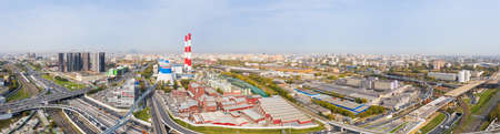 Power plant pipes and cooling towers in Moscow from above, automobile traffic and and construction of a new car overpass and interchange in the Moscow industrial zone near the automobile ring highway.の写真素材