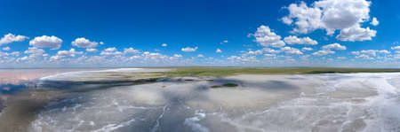 amazing panorama of Lake Elton on a summer day, beautiful sky with clouds and its reflection in the waterの写真素材