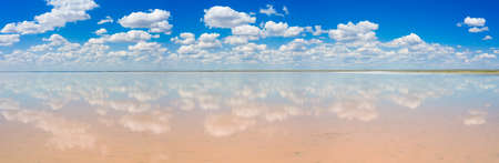 amazing panorama of Lake Elton on a summer day, beautiful sky with clouds and its reflection in the waterの写真素材