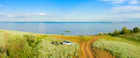 The bank of the Volga river near Saratov, travelers by car and a tent camp in natureの写真素材