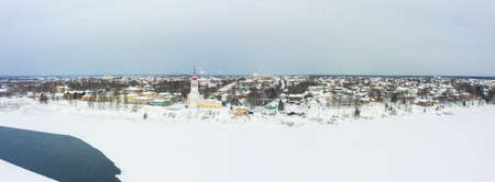 Panorama of a small city in the depths of Russia from a height. Orthodox churches and traditional old wooden houses, Totma and winter city viewの写真素材