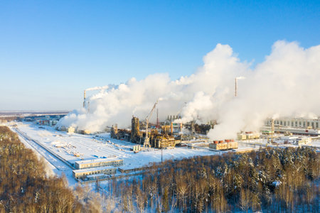 Industrial landscape. Panoramic view of the technological pipe and industrial infrastructure. Chemical production with red-white pipes and smoke is coming. Production buildingsの写真素材