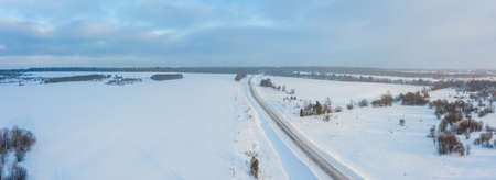 winter road with ice on the asphalt, trees under snow during the winter frost in Russiaの写真素材