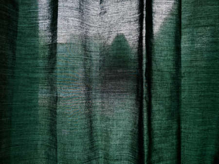 The background of the curtains on the green building window is dreamy because it is exposed to the sunの写真素材