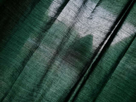 The background of the curtains on the green building window is dreamy because it is exposed to the sunの写真素材