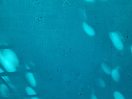 The background of the walls of the building is painted blue in the sun and there are shadows