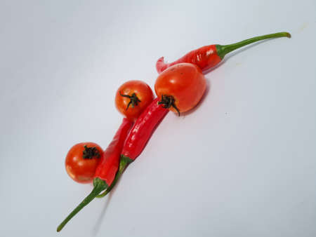 Big red chilies with green handles and big red chilies on a white background for extra cooking spicesの写真素材