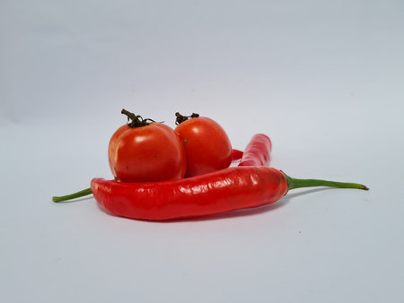 Big red chilies with green handles and big red chilies on a white background for extra cooking spicesの写真素材