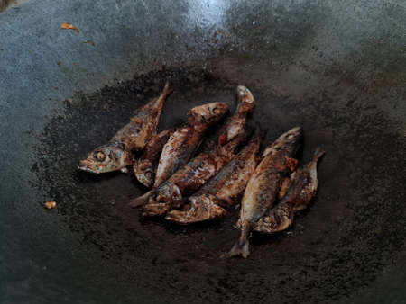 Sea fish fried in a pan with six spicesの写真素材