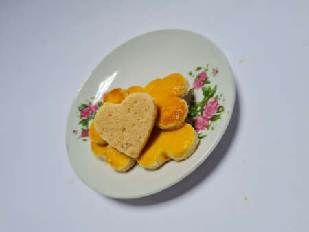 A small snack from Indonesia in the shape of a brown heart made of peanut flour and other ingredients is called peanut cakeの写真素材