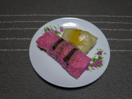 Red pancake rolls and mendut cake on a white plate