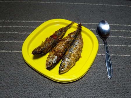 Three sea fish cooked with sweet and sour taste in a yellow container