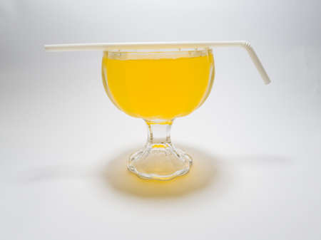 Orange flavored drink in glass cup on white backgroundの写真素材
