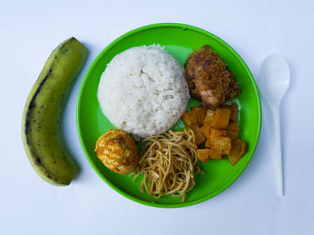 Mixed rice with side dishes, fried noodles, fried chicken, sliced fried potatoes and spicy eggの写真素材