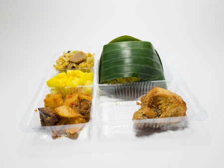 Yellow rice with fried chicken, fried chili sauce, fried noodles plus picklesの写真素材