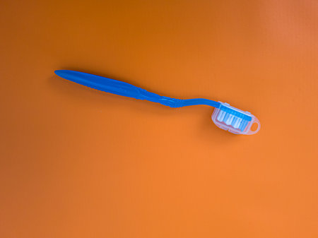 Blue toothbrush on orange backgroundの写真素材