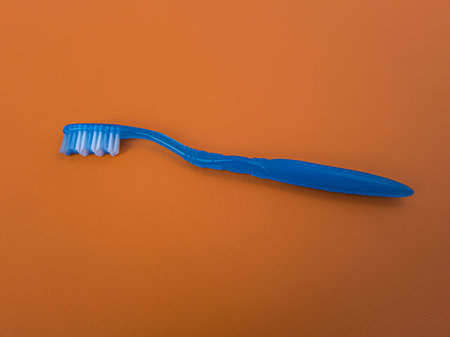 Blue toothbrush on orange background