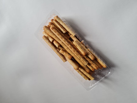 Snacks, namely crispy, savory sticks, in a plastic container