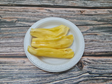 Slices of ripe yellow jackfruit in a container